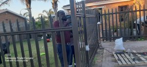 Supar Steel technician using a power tool to install a spear-top steel security fence panel