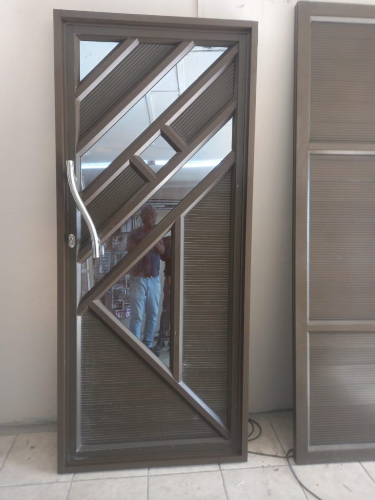 Bronze aluminium sliding door with diagonal sunburst panel design in a Cape Town workshop